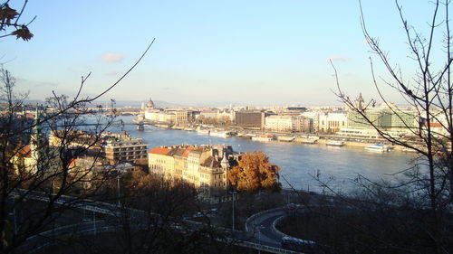 View of city by river against clear sky