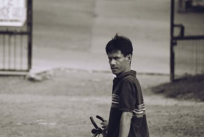 Side view of boy standing on street looking back