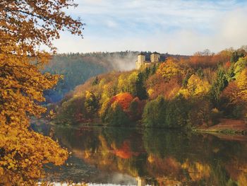 Scenic view of lake by trees against sky during autumn