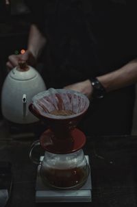 Close-up of hand holding coffee on table