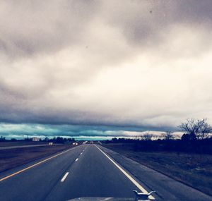 Empty road against cloudy sky