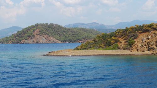 Scenic view of sea and mountains against sky