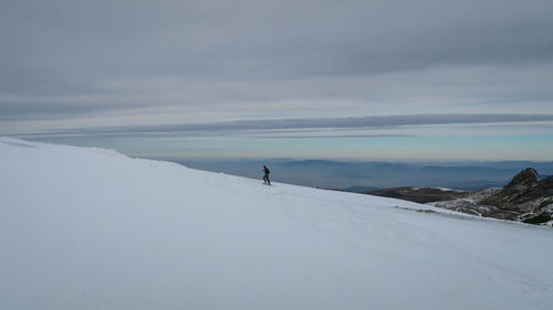 Man on snow covered mountain against sky