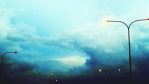 Low angle view of street light against cloudy sky