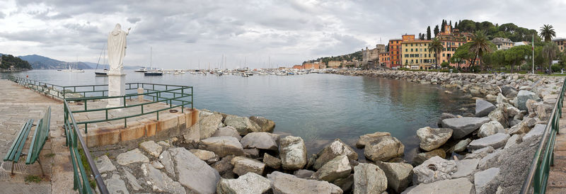 Scenic view of river by buildings against sky