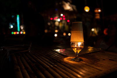 Close-up of wine glass on table at night