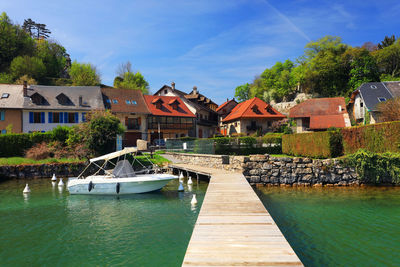 Houses by river against sky