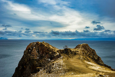 Rock formation on beach against sky