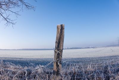 Wooden fence on field against clear sky