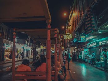 People on illuminated street at night