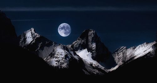 Scenic view of snowcapped mountains against sky at night