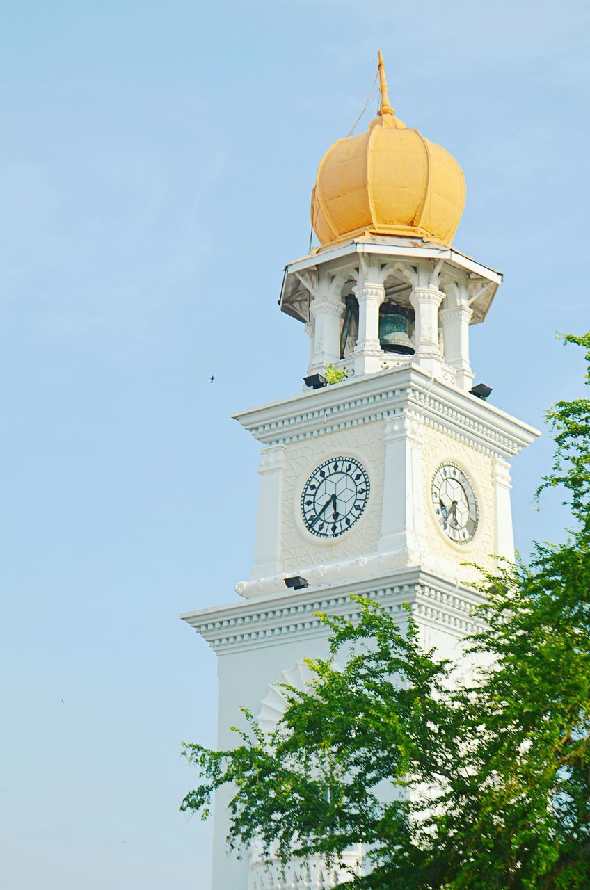 religion, low angle view, place of worship, building exterior, architecture, spirituality, church, built structure, clear sky, tower, clock tower, high section, cross, tree, blue, cathedral, sky, bell tower