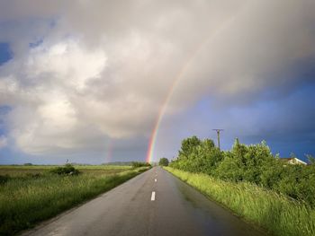 Double rainbow seen at the end of an empty road