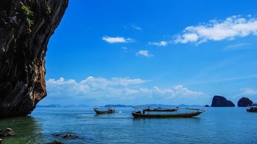 Boats in sea against blue sky