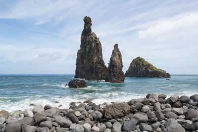 Rocks in sea against sky