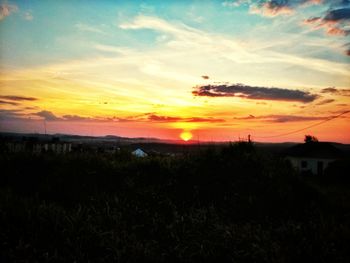 Scenic view of silhouette field against sky during sunset