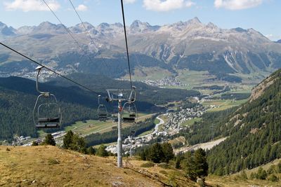 Overhead cable car over mountains against sky