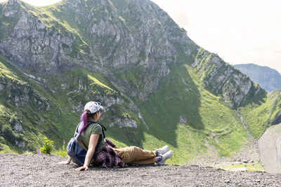 Side view of woman sitting on mountain