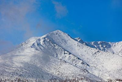 Scenic view of snowcapped mountains against clear blue sky
