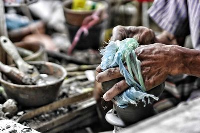 Midsection of man working on pottery wheel