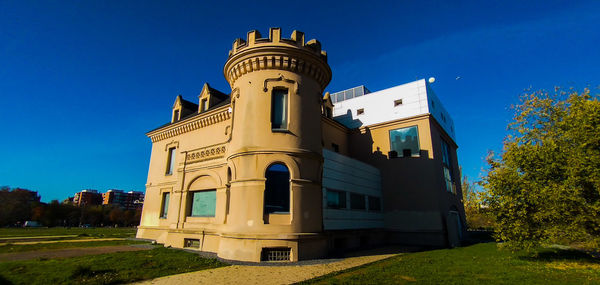 Low angle view of building against clear blue sky