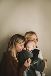 Mothers hugging sleeping newborn baby