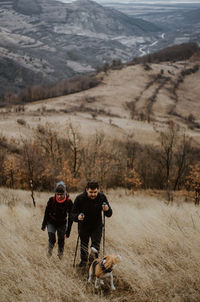 High angle view of couple with dog hiking on mountain