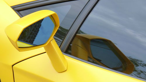 Close-up of yellow car on side-view mirror