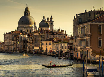 Canal by santa maria della salute and buildings against sky