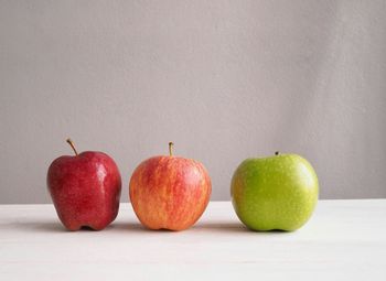 Close-up of apples on table against white background