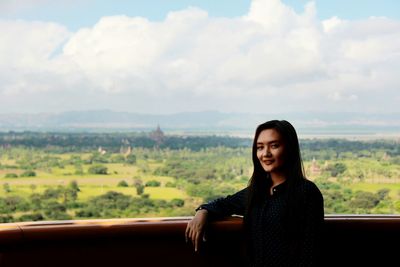 Portrait of young woman looking at landscape