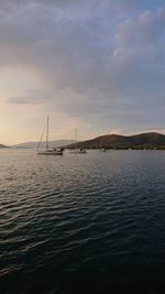 Sailboat in sea against sky during sunset