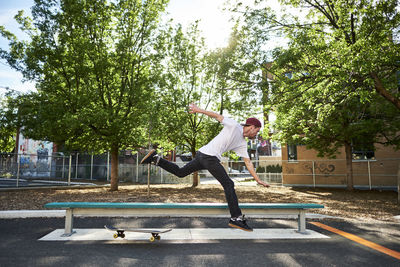 Skateboard dude falling while trying to grind bench in park