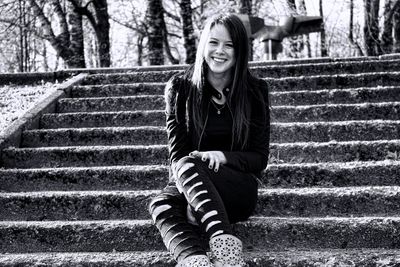 Portrait of smiling woman sitting on staircase