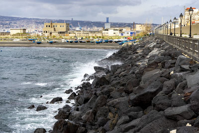 Scenic view of sea by buildings against sky