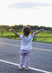 Rear view of boy standing on road