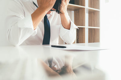 Low section of man sitting on table