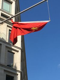 Low angle view of flag against clear blue sky