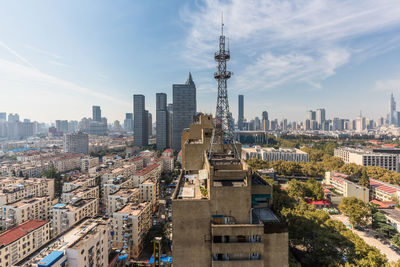 High angle view of city buildings against cloudy sky