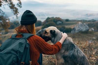 Midsection of woman with dog against sky