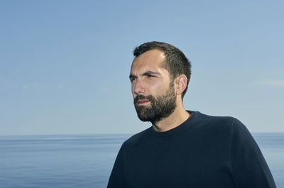 Portrait of man looking at sea against sky