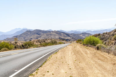 Road leading towards mountains against sky