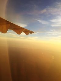 Airplane flying in sky during sunset