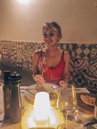 Portrait of a smiling young woman sitting on table