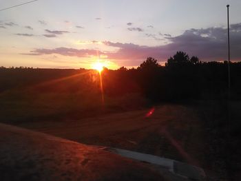 Scenic view of landscape against dramatic sky during sunset