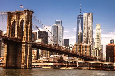 Bridge over river against buildings in city