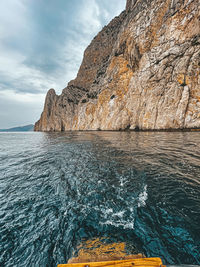 Rock formations by sea against sky