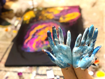 Close-up of hand holding multi colored pencils