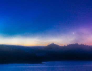 Scenic view of lake against sky at night