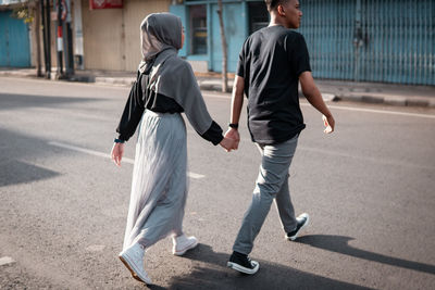 Rear view of people walking on street